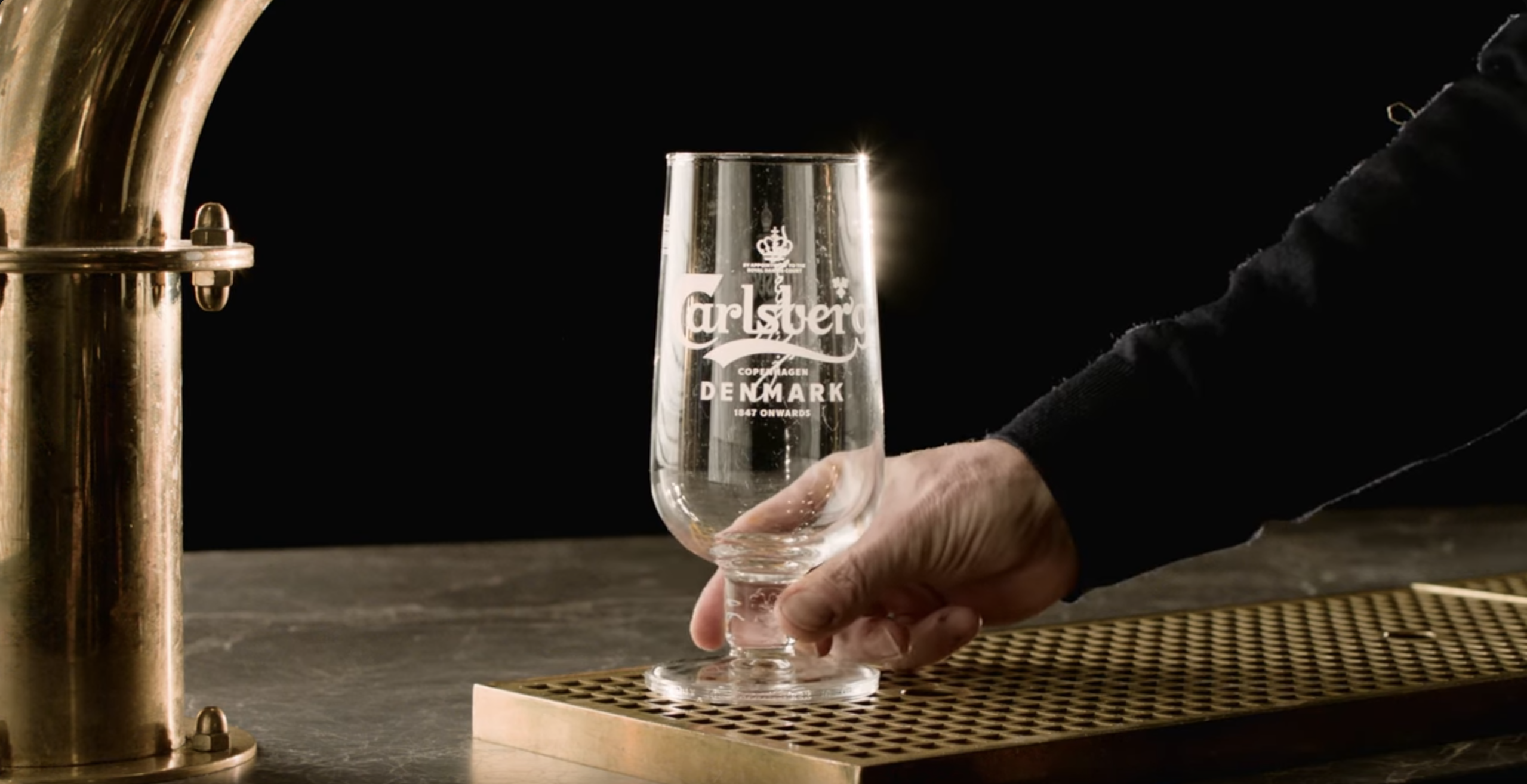 A person holding an empty beer glass